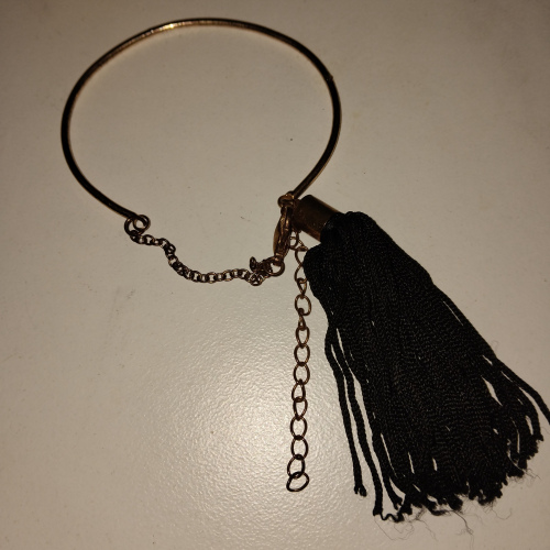 gold bangle with black tassle