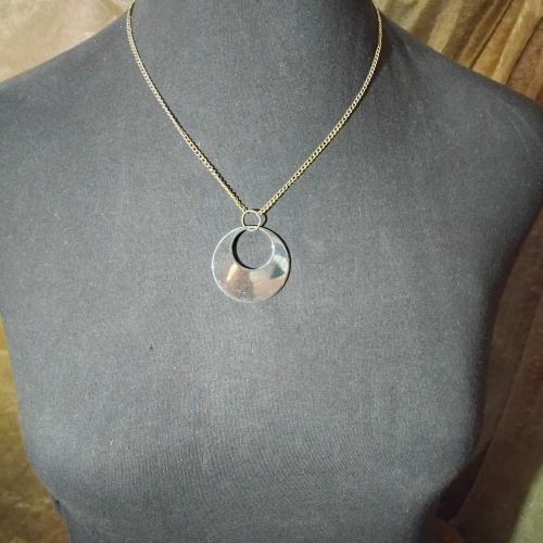 silver round pendant with whole gold necklace